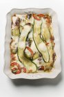 Pfeffer-Zucchini-Gratin auf weißem Teller über weißer Oberfläche — Stockfoto