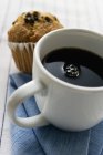 Tasse de café avec un muffin — Photo de stock