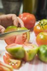 Mano humana Cortando tomates - foto de stock