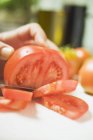 Couper les tomates à la main humaine — Photo de stock