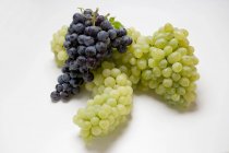 Bunches of green and black grapes — Stock Photo