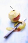 Pomme demi-pelée avec couteau — Photo de stock
