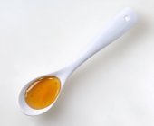 Cucharada blanca de miel - foto de stock