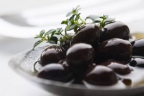 Маринованные черные оливки в тарелке — стоковое фото