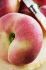 Ripe peach and knife — Stock Photo