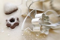 Closeup view of assorted biscuit cutters and biscuits with icing sugar — Stock Photo