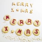 Nahaufnahme von fröhlichen Weihnachtskeksen auf weißer Oberfläche — Stockfoto