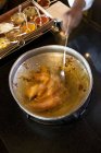 Vista ritagliata elevata di mano mescolando salsa di montone — Foto stock