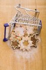 Christmas biscuits in mini shopping trolley — Stock Photo