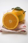 Свежий апельсин с половиной на ткани — стоковое фото