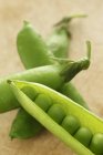 Pea pods on wooden surface — Stock Photo