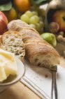 Partly sliced baguette with fruits — Stock Photo