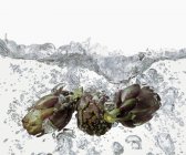 Alcachofras em água fervente — Fotografia de Stock