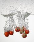 Pomodori che cadono in acqua — Foto stock