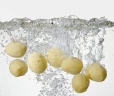 Patatas peladas en agua hirviendo - foto de stock