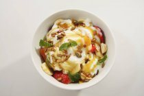 Fruit salad with yogurt and pine nuts — Stock Photo