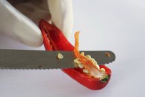 Human hand deseeding out of pepper — Stock Photo