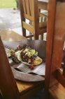Elevated daytime view of Burrito on a leaf on a wooden bench — Stock Photo