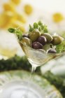 Schwarze und grüne Oliven im Cocktailglas — Stockfoto