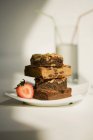 Brownies che servono impilati sul piatto con fragola — Foto stock