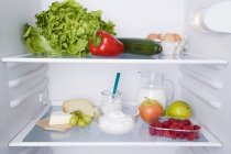 Открытый холодильник с различными видами свежих продуктов — стоковое фото