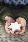 Обрізаний вид рук, що тримає печиво у формі зірки — стокове фото