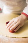 Closeup view of child cutting out biscuits — Stock Photo