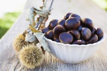 Chestnuts in white bowl — Stock Photo