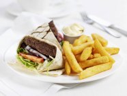 Meat burger wrap with chips — Stock Photo