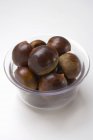 Several chestnuts in glass bowl — Stock Photo