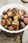Roasted chestnuts in white bowl — Stock Photo