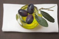 Чорні оливки і баночка з оливковою олією — стокове фото