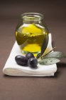 Чорні оливки і баночка з оливковою олією — стокове фото