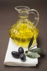 Olives and carafe of olive oil — Stock Photo