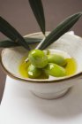 Olives vertes sur brindilles dans un bol — Photo de stock