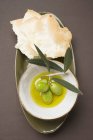 Olive verdi su ramoscello in olio d'oliva — Foto stock