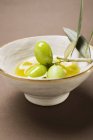 Olives vertes sur brindilles dans un bol — Photo de stock
