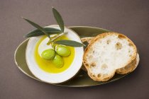 Grüne Oliven auf Zweigen in Olivenöl — Stockfoto