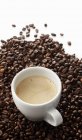 Espresso in cup on coffee beans — Stock Photo