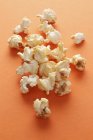 Fried Popcorn on orange — Stock Photo