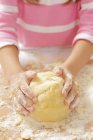 Вид крупным планом на девочку, месящую песочный хлеб — стоковое фото