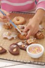 Девушка украшает печенье с глазурью сахара — стоковое фото