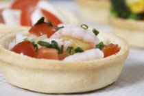 A tomato and prawn tartlet over white surface — Stock Photo