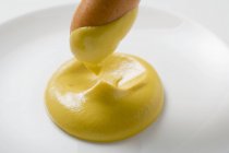 Mergulhando frankfurter em mostarda — Fotografia de Stock