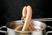 Lifting frankfurters out of hot water — Stock Photo