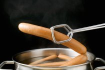 Lifting frankfurters out of hot water — Stock Photo
