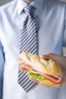Бизнесмен с ветчиной бутерброд — стоковое фото