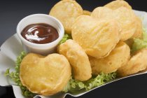 Closeup view of chicken nuggets with dip in paper dish — Stock Photo