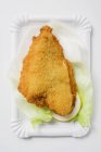 Breaded fish fillet on lettuce leaf — Stock Photo