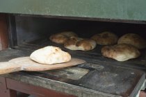 Pan de pita recién horneado en la pala - foto de stock
